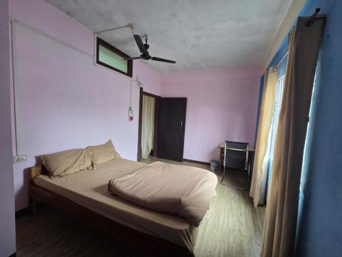 a bedroom with a bed in a room with pink walls at Anigo 3bhk, Itanagar in Itānagar