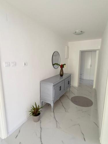 a white room with a dresser and a mirror at Fortress Apartment in Bar