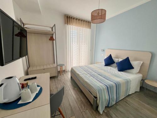 a bedroom with a bed and a flat screen tv at Dimora del Corso - Rooms in Mattinata