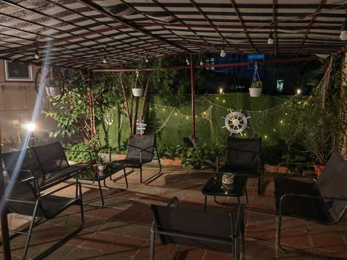 a patio at night with chairs and lights at Къща за гости Пиргос in Burgas