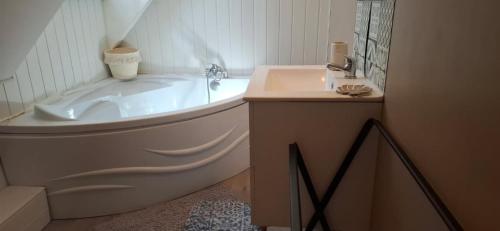 a bathroom with a tub and a sink and a toilet at Chambres - La Chenevelle in Chitenay