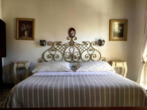 een groot bed met een metalen hoofdeinde in een slaapkamer bij Hotel Draghi in San Antonio de Areco