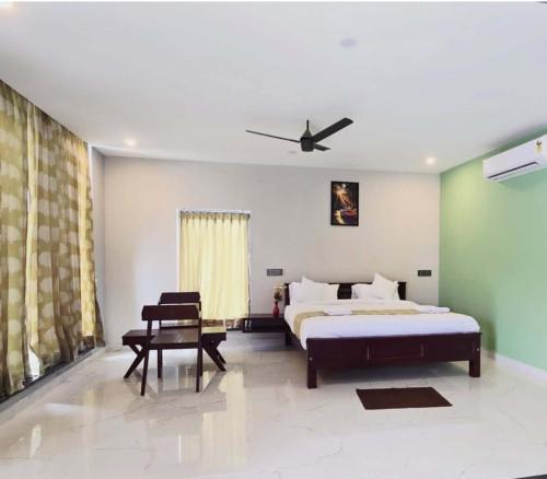 a bedroom with a bed and a ceiling fan at Silver Valley Villas in Yercaud