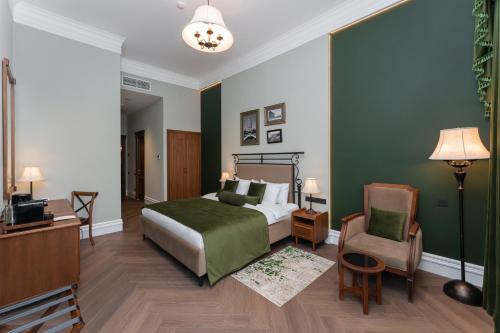 a bedroom with a bed and a desk and a chair at Hayasa Hotel Old Yerevan in Yerevan