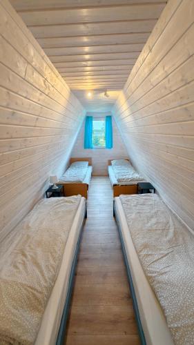 a room with three beds and a window at Nowa Siesta Camp Łeba in Nowęcin