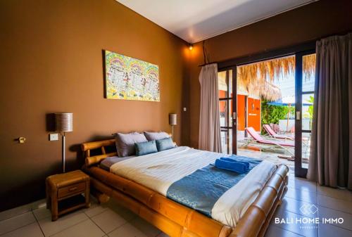 a bedroom with a large bed and a balcony at villa TOYA NING in Ungasan