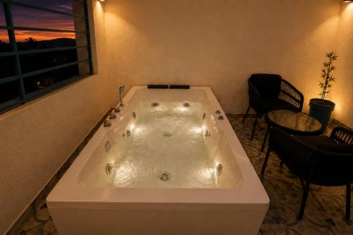 a large bath tub in a room with a window at Hotel H F at Assagao North Goa in Assagao