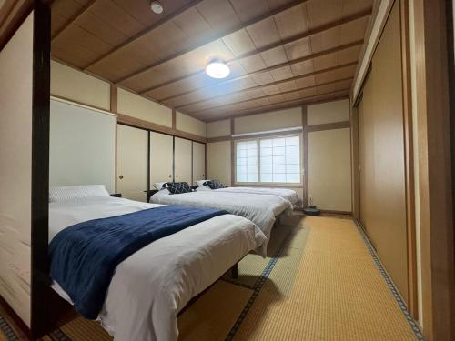 a row of four beds in a room at Guest house LIA1 in Abashiri