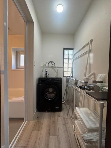 a room with a washing machine in the middle of a room at Guest house LIA1 in Abashiri