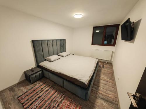 a small bedroom with a bed and a window at Casa Alina in Nehoiu