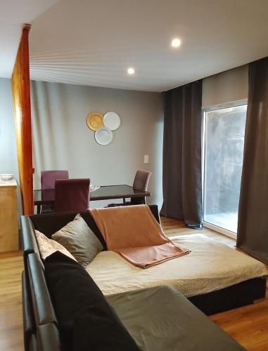 a living room with a bed and a table at Telhadosolitario in São Pedro da Cova