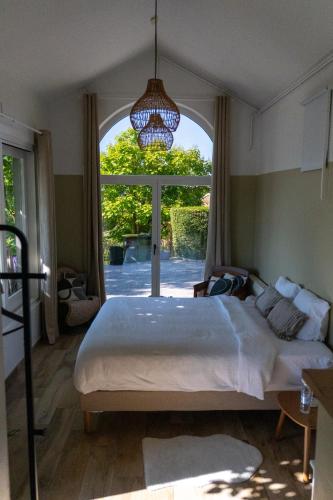 a bedroom with a large bed and a large window at Atelier n°5 in Wanze