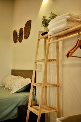 a wooden bunk bed with a ladder next to a bed at Outdo'r Garden House in Tuy Hoa