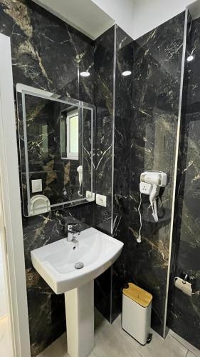 a bathroom with a sink and a mirror at Laska's Rooms Sarandë in Sarandë