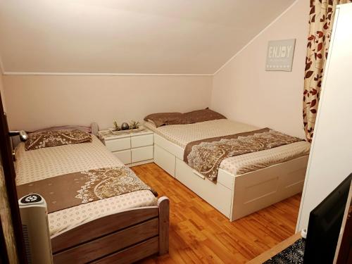 two beds in a small room with wooden floors at Casa Naomi in Eforie Nord