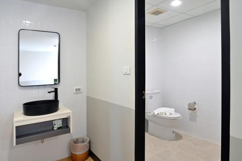 a bathroom with a toilet and a mirror at Anya Nana at Sukhumvit Bangkok in Bangkok