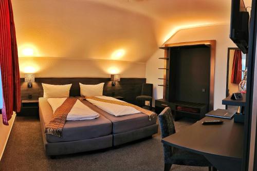 a bedroom with a bed and a desk and a desk at Wilbergerhof RoyalThai in Horn-Bad Meinberg