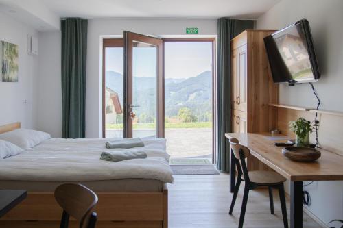 a bedroom with a bed and a desk and a television at Nad vasjo in Železniki