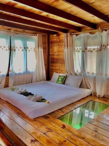 a large bed in a room with a glass floor at Keereethara chiewlarn in Ban Bang Kaeo