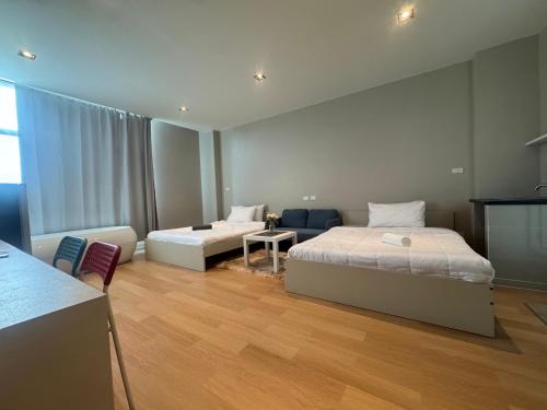 a large room with two beds and a couch at The Elegant Bangna Suvarnabhumi in Ban Map Prasoe