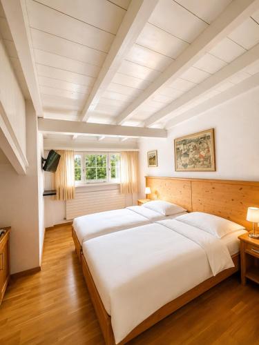 a large white bedroom with a large white bed at Hotel Alpenblick in Klosters