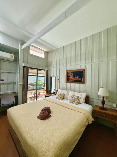 a bedroom with a large bed with a hat on it at tamarind guesthouse in Phra Nakhon Si Ayutthaya