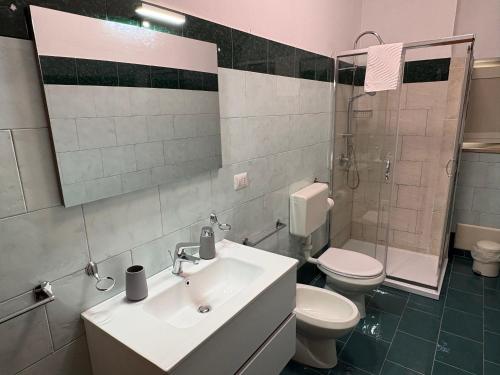 a bathroom with a sink and a toilet and a mirror at Chill House Reggio Calabria in Reggio di Calabria