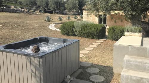 a dog sitting in a hot tub in a yard at Casa Farfaglia in Noto
