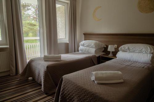 a hotel room with two beds with towels on them at Nidos SKALVA in Neringa
