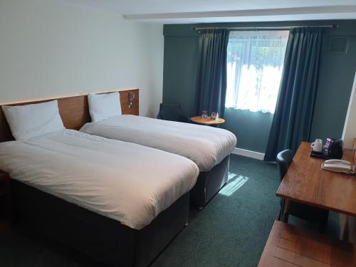 a hotel room with two beds and a window at Legacy Preston International Hotel in Preston