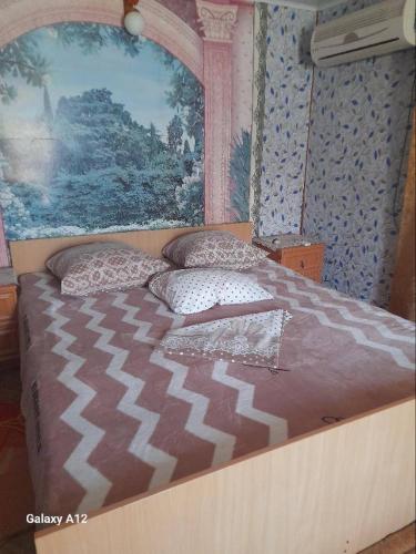 a bedroom with a large bed with pillows on it at Кооператив Радуга in Rasseyka