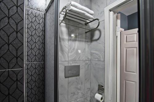 a bathroom with a shower with white marble walls at Denizli Hotel in Istanbul