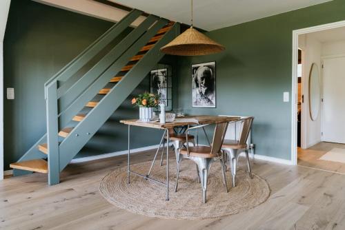 a dining room with a table and a staircase at Chiemgau Nest II in Siegsdorf