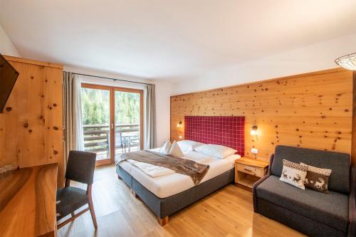 a bedroom with a bed and a chair and a couch at Hotel Alcialc in La Valle