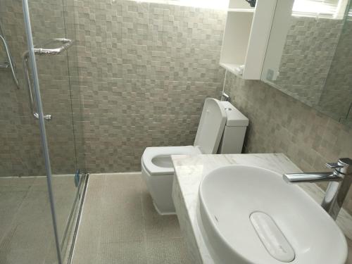 a bathroom with a toilet and a sink and a shower at Modern and quiet Condo BKK1 - Rooftop Pool in Phnom Penh