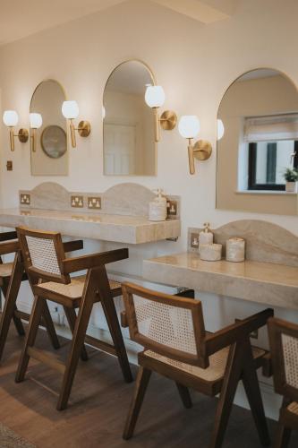 a bathroom with two sinks and chairs and mirrors at Longridge House in Longridge