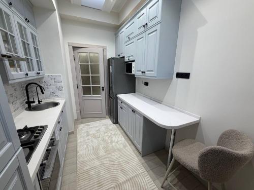 a white kitchen with a sink and a refrigerator at Top1 Gardens Residents in Tashkent