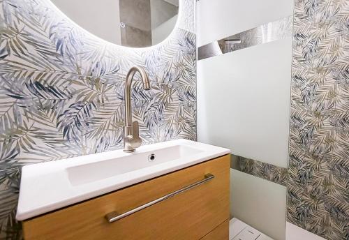 a bathroom with a sink and a wall at Vue Lac Léman & Télécabine à 1 minute in Thollon