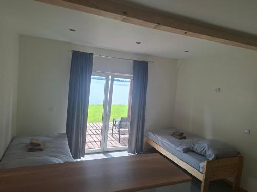 a bedroom with two beds and a window with a balcony at J&L Lake Resort in Grądzkie