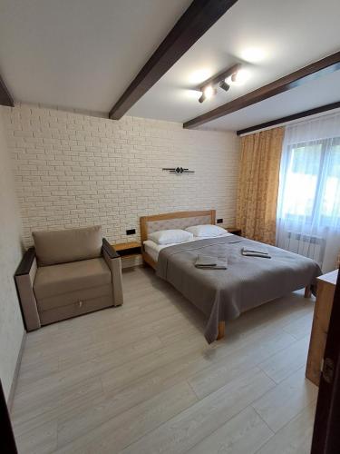 a bedroom with a bed and a chair in it at Вершина Мрій in Slavske