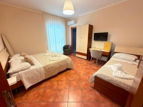 ein Hotelzimmer mit zwei Betten und einem Schreibtisch in der Unterkunft Suite 04 in Airola