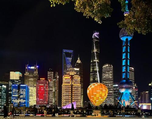 a city skyline at night with hot air balloons at Atour Hotel Shanghai Lujiazui Babaiban in Shanghai