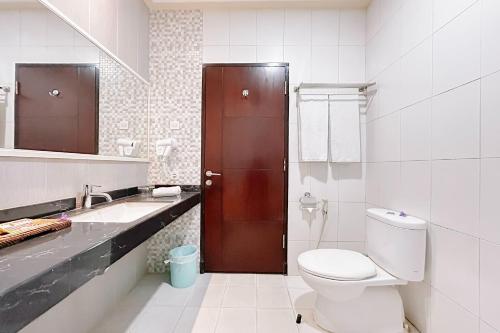 a bathroom with a toilet and a sink at Hotel Puri Indah & Convention in Tjakranegara