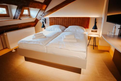 a bedroom with a large bed with white sheets and pillows at Die Burg - Kurfürstlich Flämisch in Bad Belzig