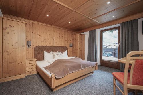 a bedroom with a bed in a room with a window at Appartements Alpenrose in Längenfeld
