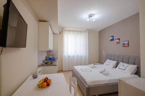 a bedroom with a bed and a table with fruit on it at Elidon Apartments in Sarandë
