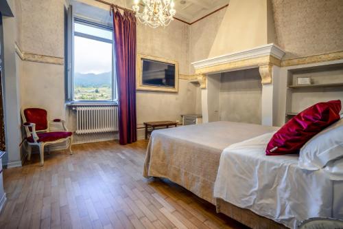 a bedroom with a bed and a large window at Hotel Oviv - La dimora del Borgo in Acquaviva Picena