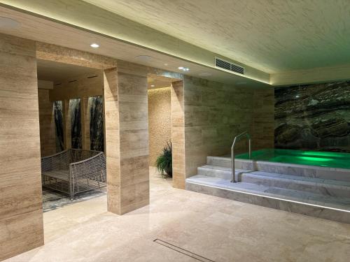 a swimming pool in a room with a tub at Harmony Birštonas in Birštonas
