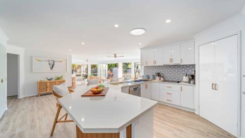 a kitchen with white cabinets and a white counter top at Salt n Sand Beach house - 10min walk to Ocean - Idyllic coastal village in Ocean Shores