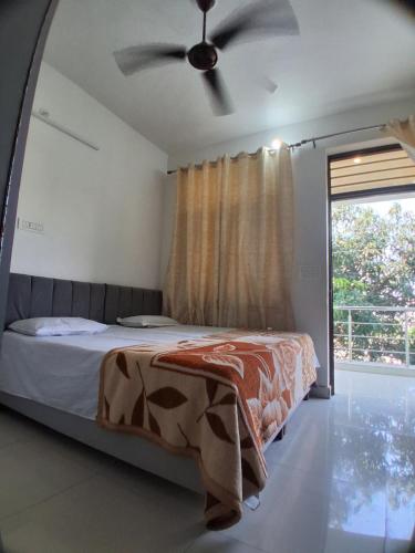 a bedroom with a bed and a ceiling fan at Guruji Homestay Near UPES Collage in Jhājra